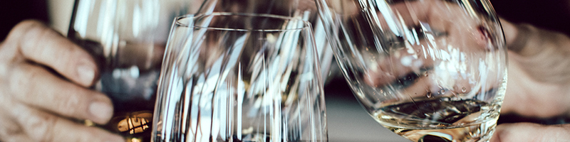 Des mains tenant des coupes de vin trinquent ensemble